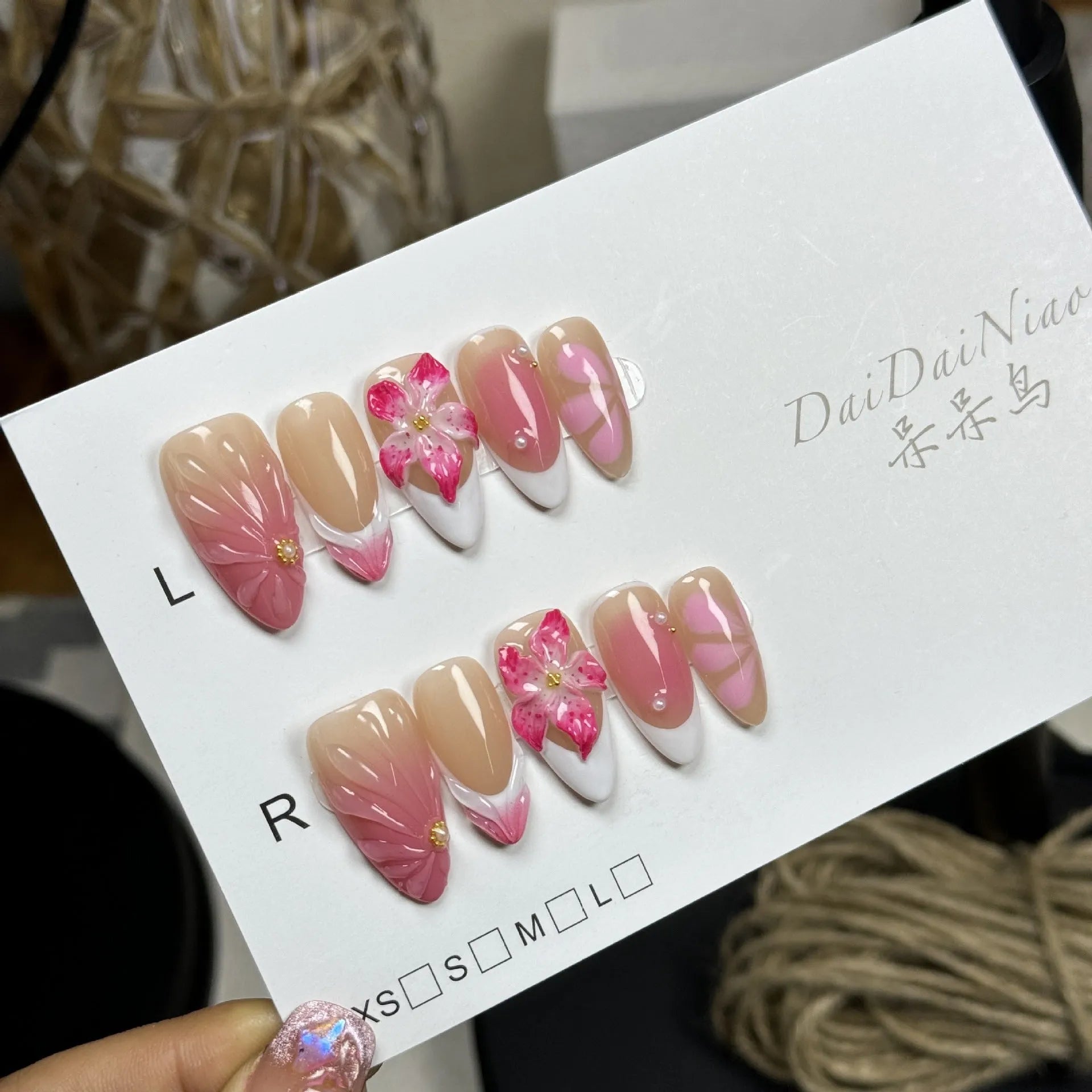 French style three-dimensional lily ice flower gel nail stickers in almond shape on plastic backing.
