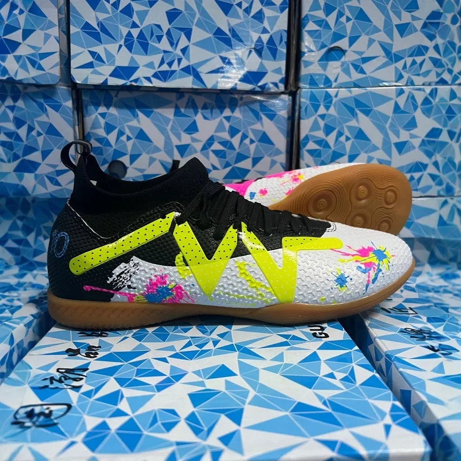 Men's black and yellow football boots with removable rubber studs on artificial grass