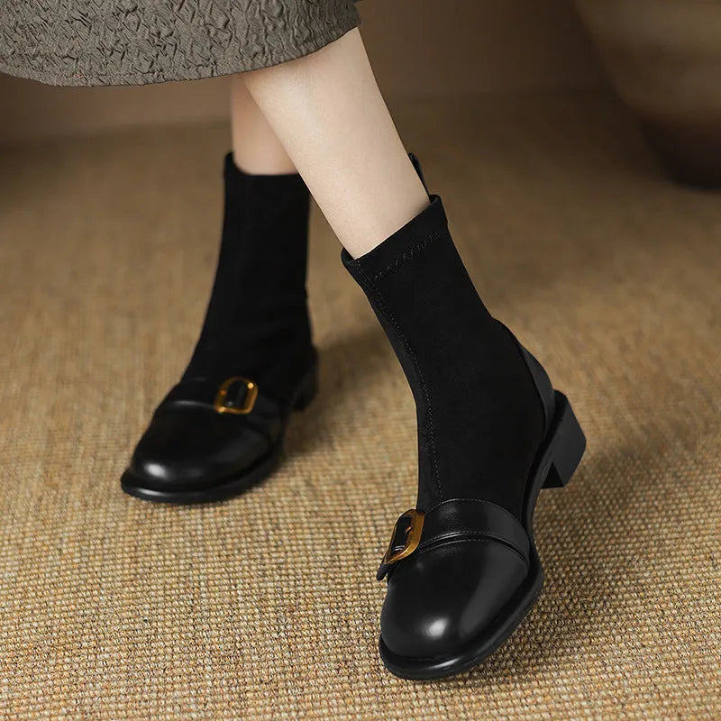 Women's black low-heel Martin boots with belt buckle detail and front lace-up fastening.