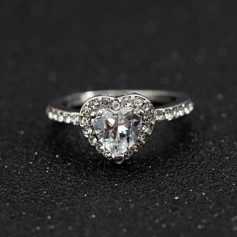Heart-shaped women's ring with crystal decoration in rose gold or silvery finish on a size chart.