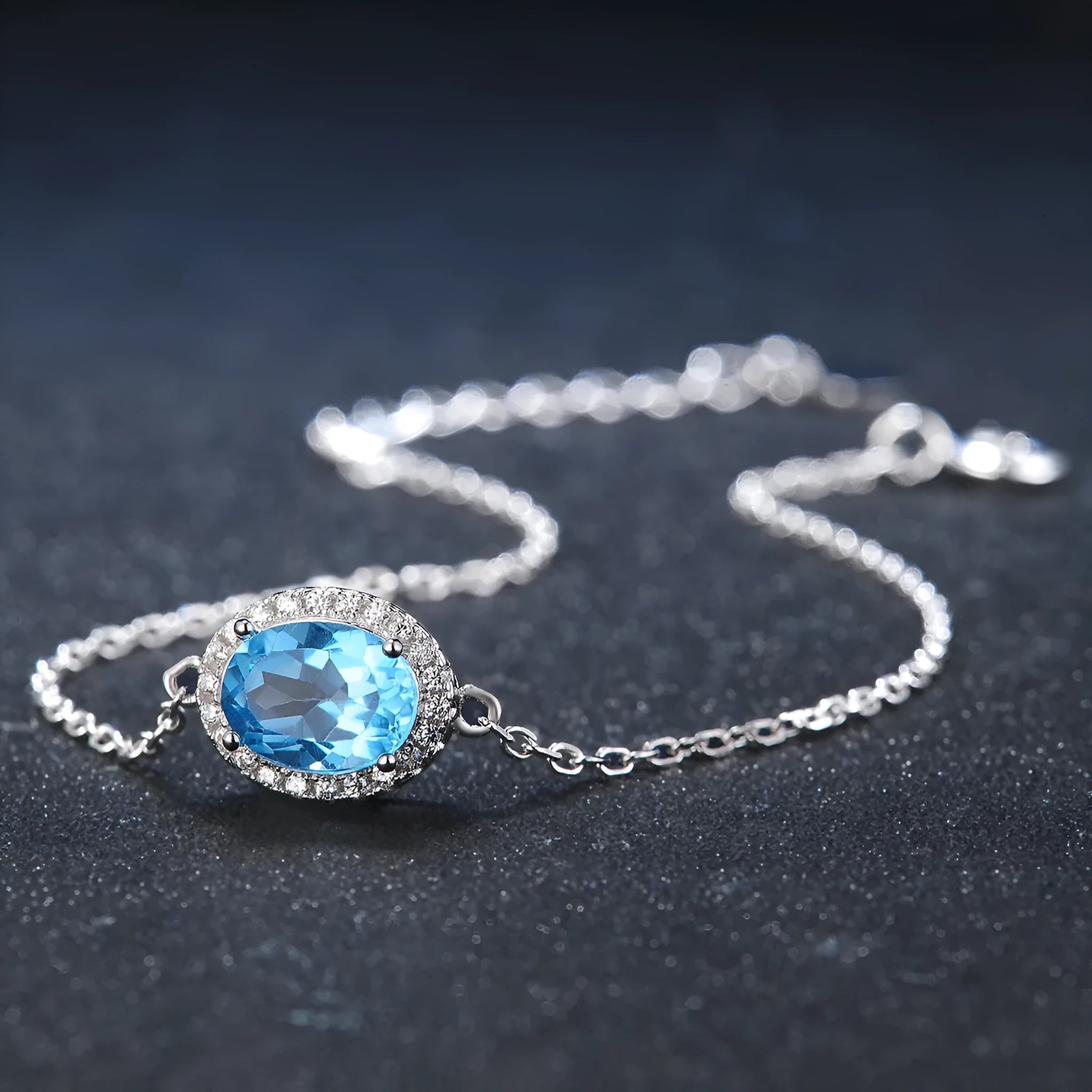 Women's sterling silver jewellery set with blue topaz gemstones in geometric design including earrings, ring, pendant, and necklace