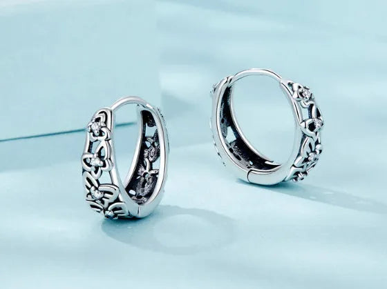 Sterling silver hollow butterfly earrings with zircon accents on white background