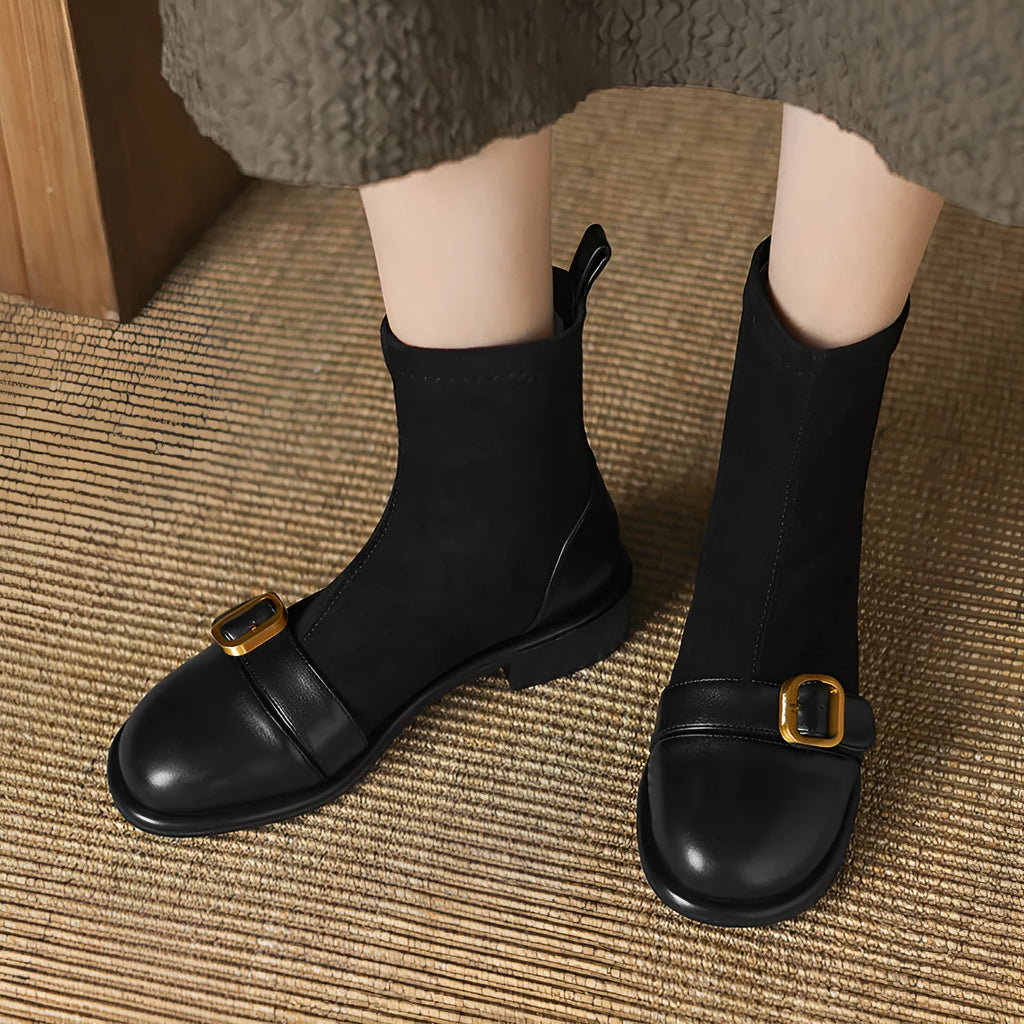 Women's black low-heel Martin boots with belt buckle detail and front lace-up fastening.