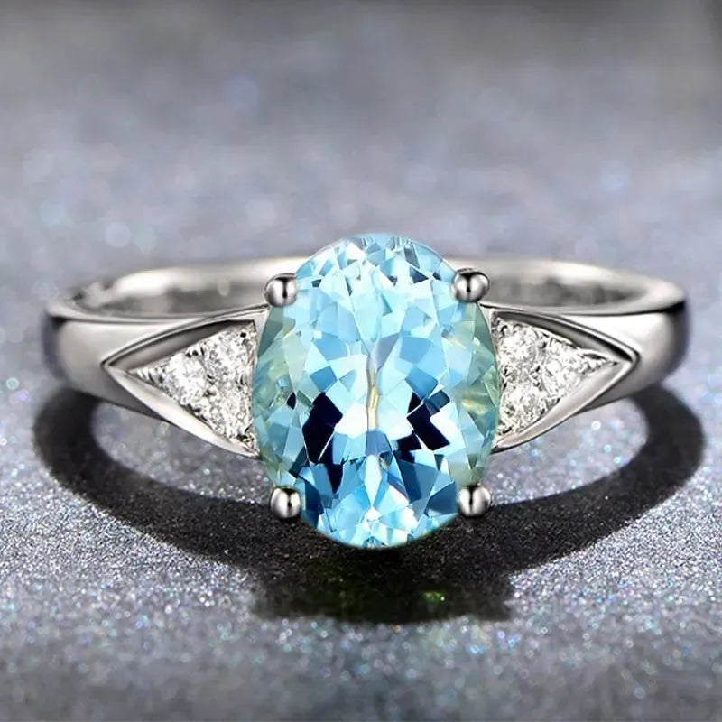 Close-up of a women's court style ring with a red zircon set in a heart-shaped pattern.