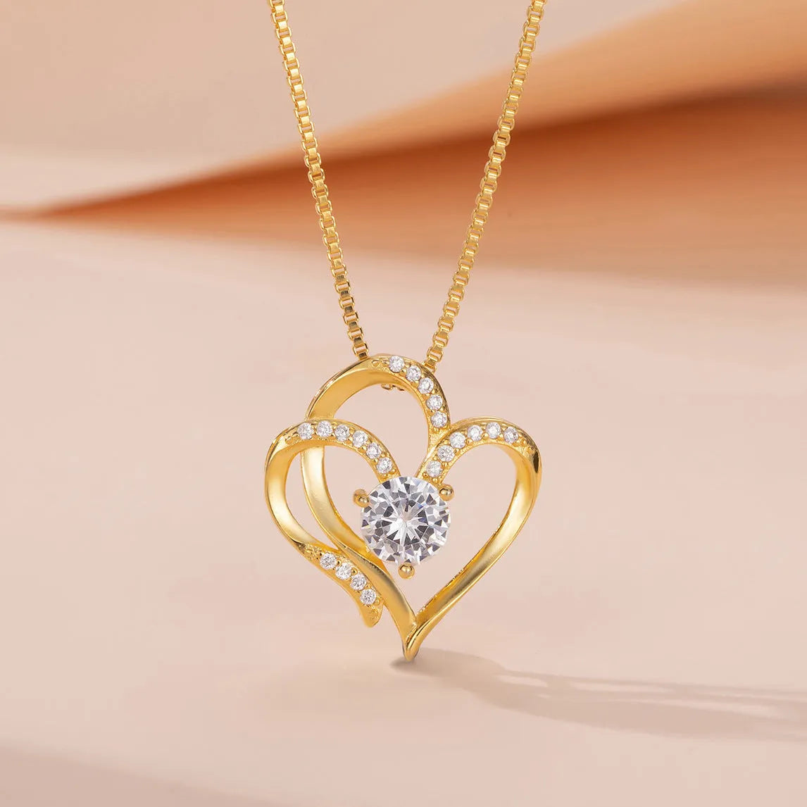 Women's heart-shaped silver necklace shown in rose gold, white gold, and yellow gold plating variations.