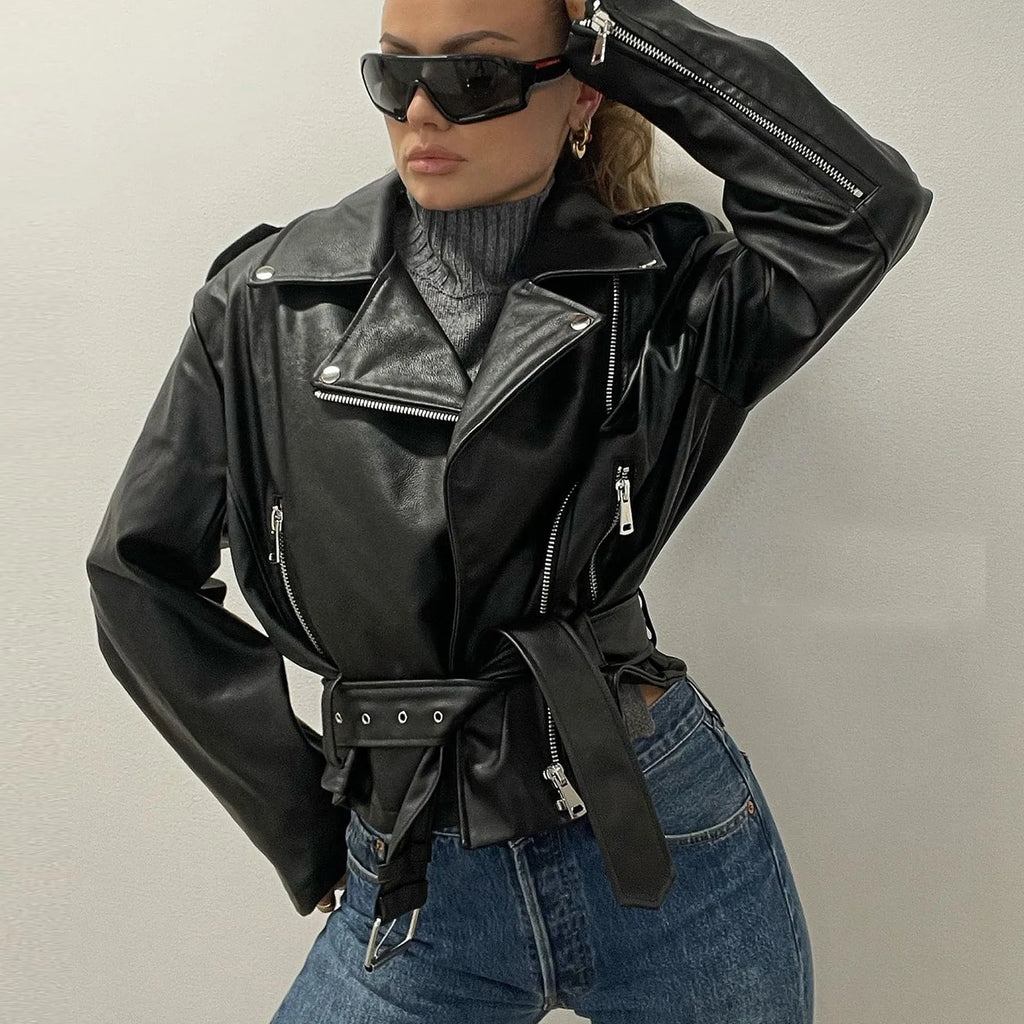 Black punk style short leather jacket with a Peter Pan collar and drawstring waist on a hanger.