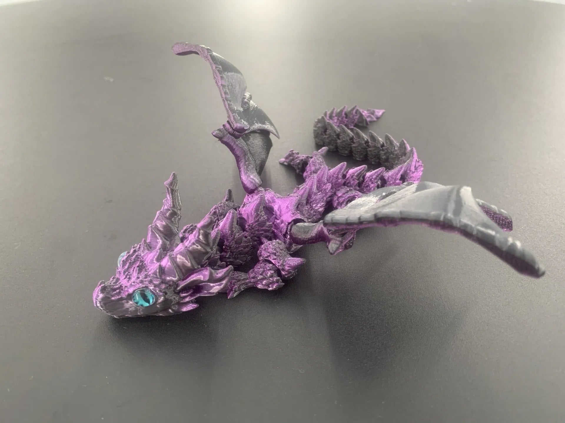 Red and gold 3D printed dragon wings toy decoration on a white background.