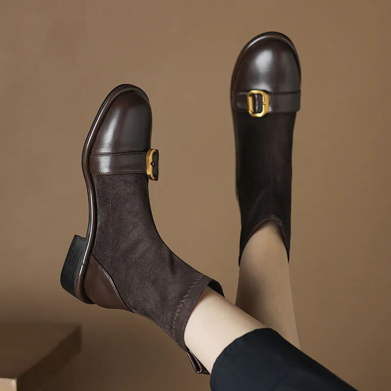 Women's black low-heel Martin boots with belt buckle detail and front lace-up fastening.