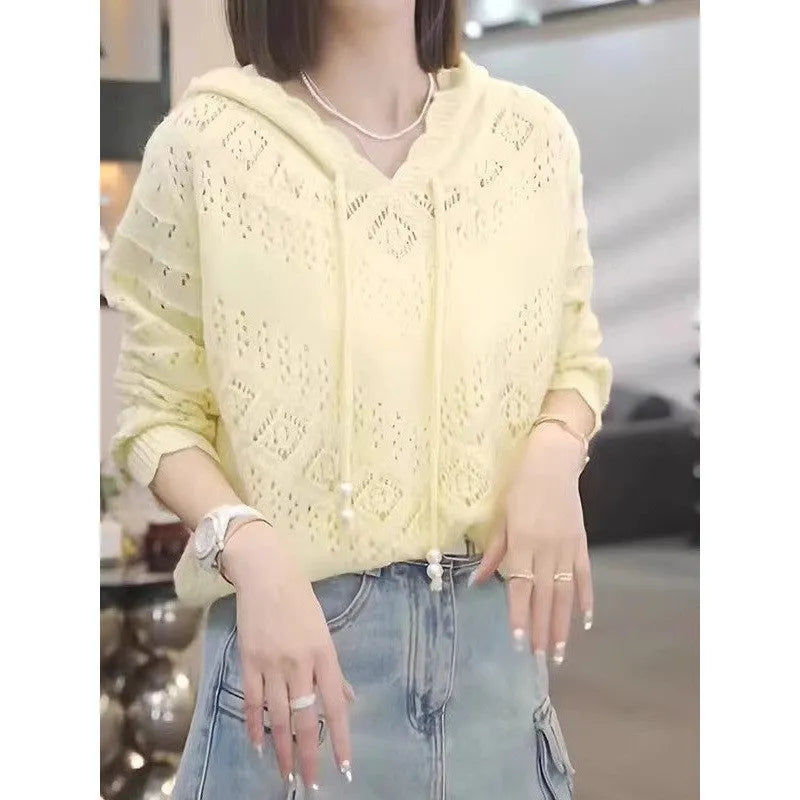 Woman wearing a light blue, hooded crochet longsuit undershirt with a hollow knit pattern and long sleeves.