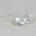 Silver zinc alloy earrings with glossy bird motif and floral leaf design