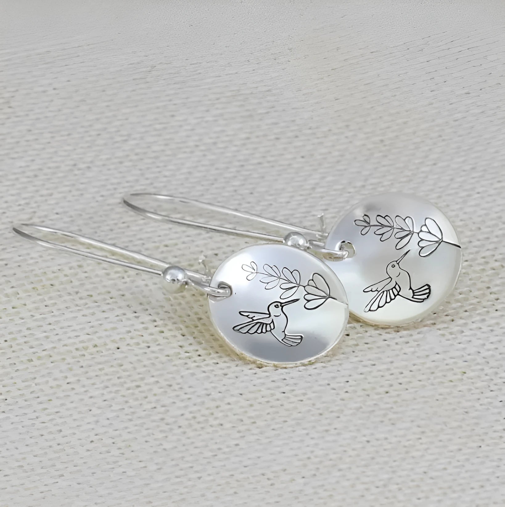 Silver zinc alloy earrings with glossy bird motif and floral leaf design