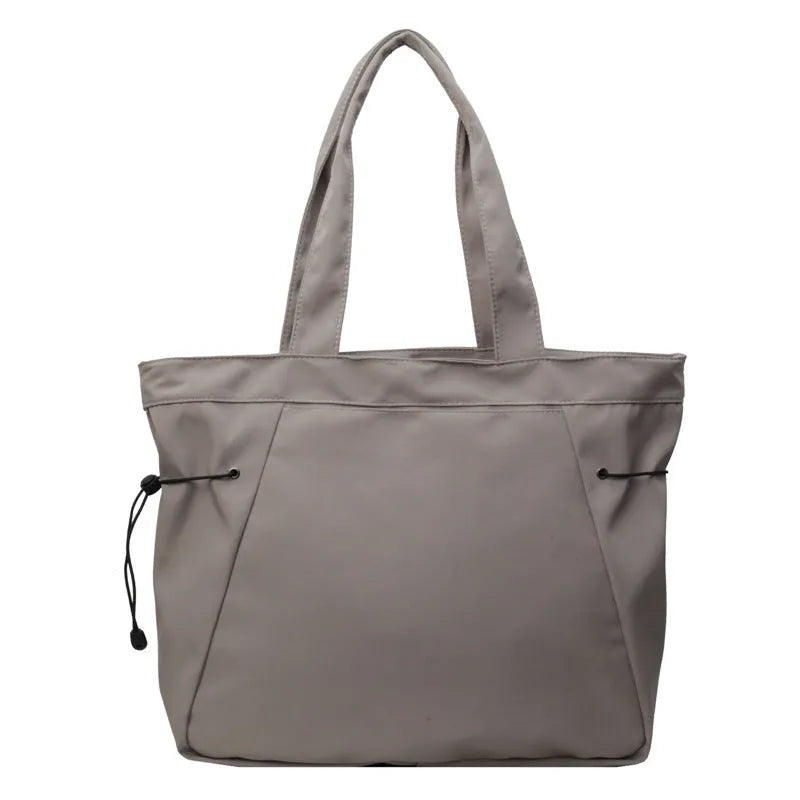 Soft Oxford cloth commuter tote bag in a street style, shown in a folded position.
