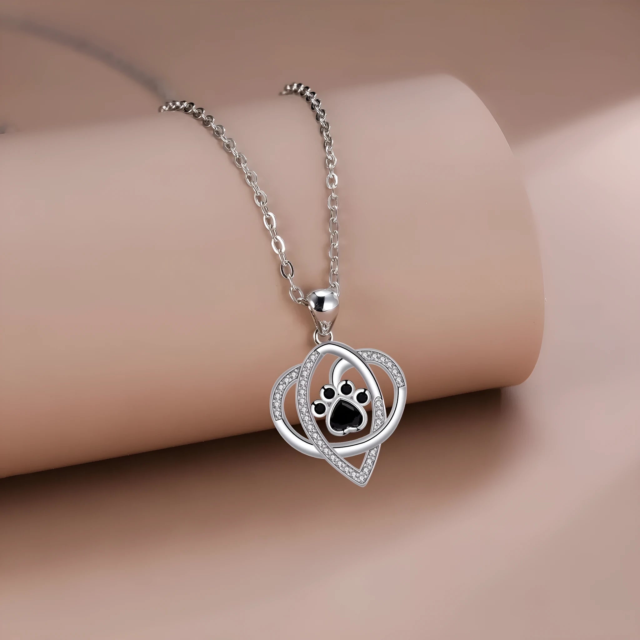 Copper pendant necklace with dog and cat paw print design on a cross chain