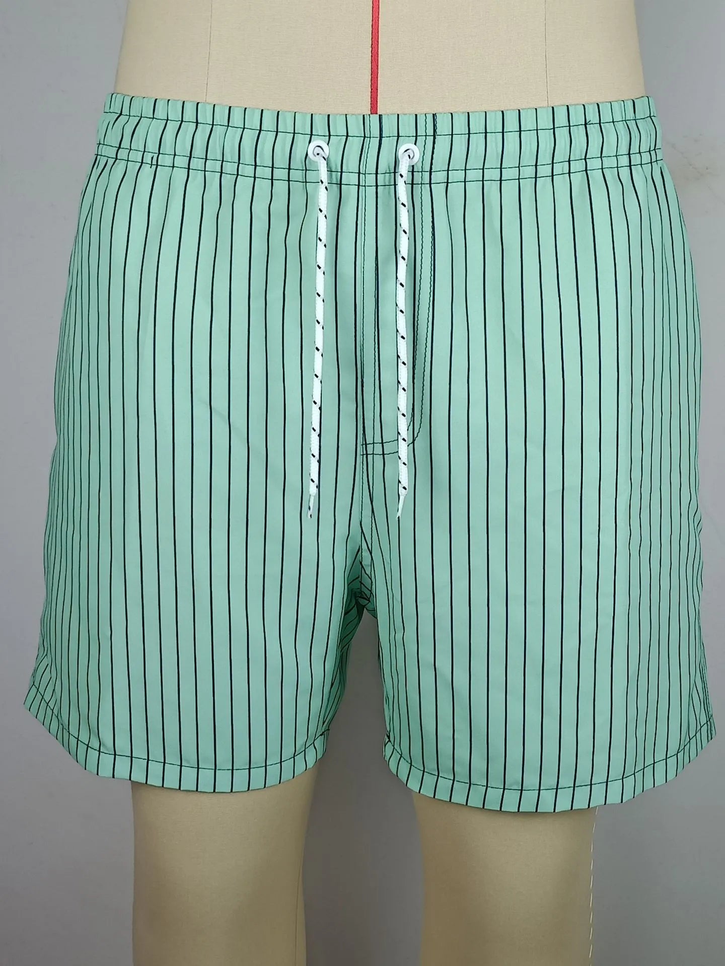 Men's striped beach shorts in polyester blend fabric, showing straight leg opening and available colour options.