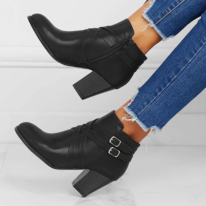 Women's black short boot with 7cm heel, side zipper, belt buckle, and rubber sole