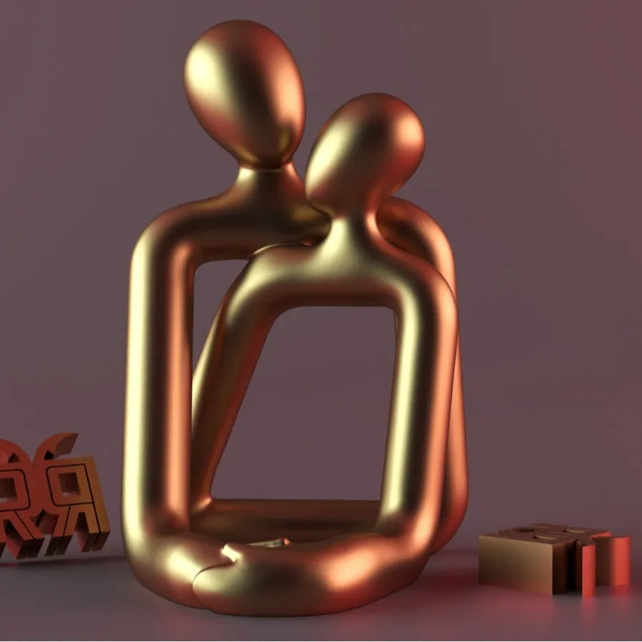 Modern loving couple resin statue in gold or milky white on a wooden shelf.