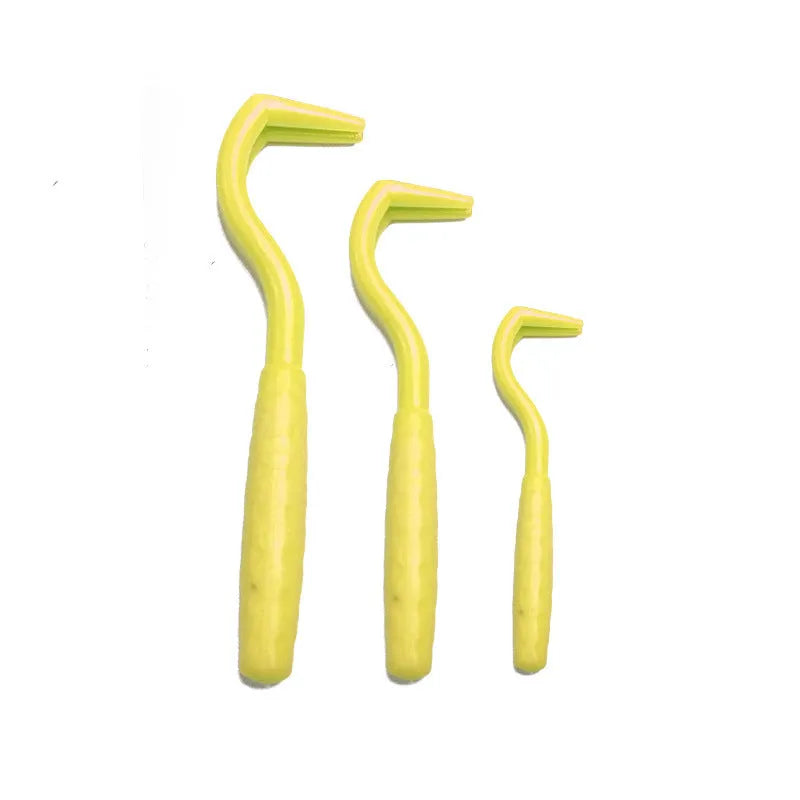 Set of three coloured tick removal hooks for dogs on a white background.
