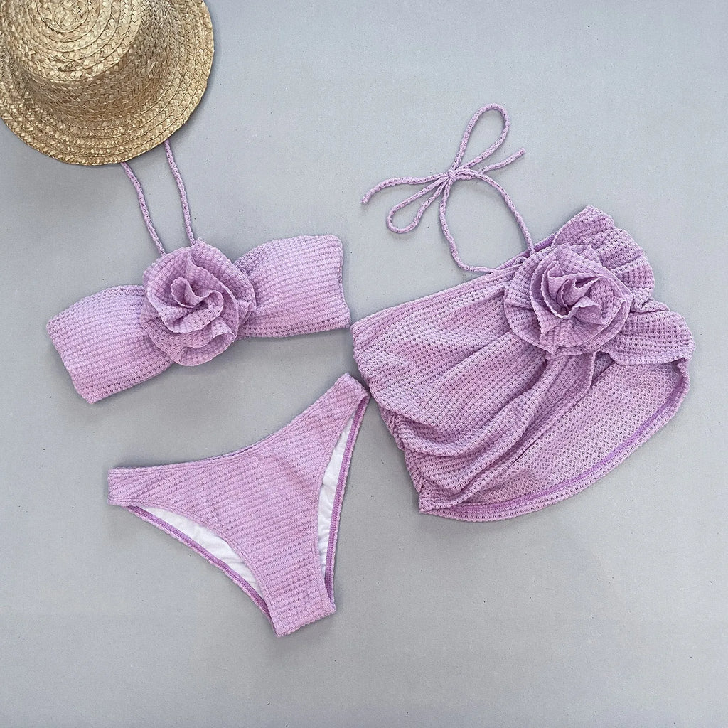 Women's purple three-piece bikini set with 3D flower split detail on swimsuit