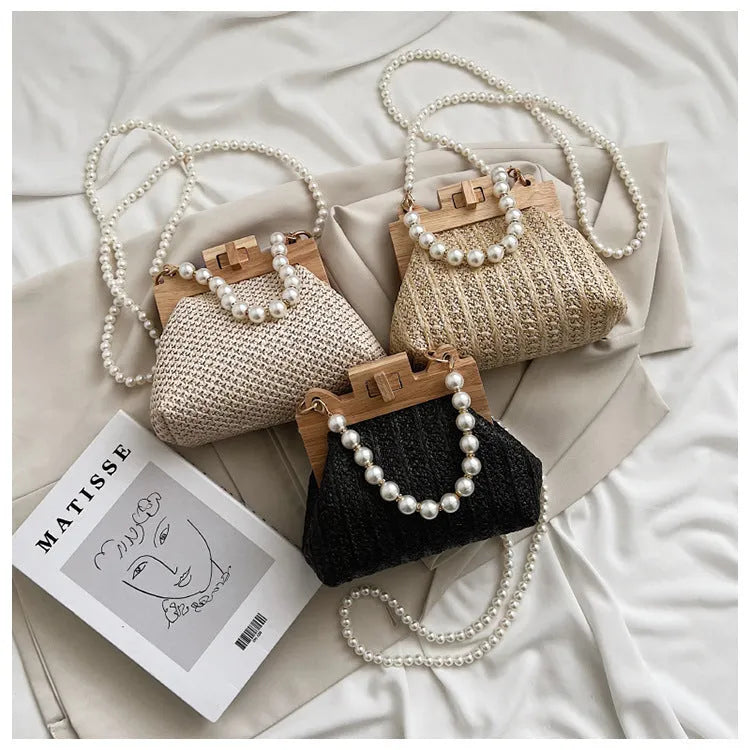 Women's straw woven shoulder bag with pearl chain strap in horizontal square shape showing internal organisers