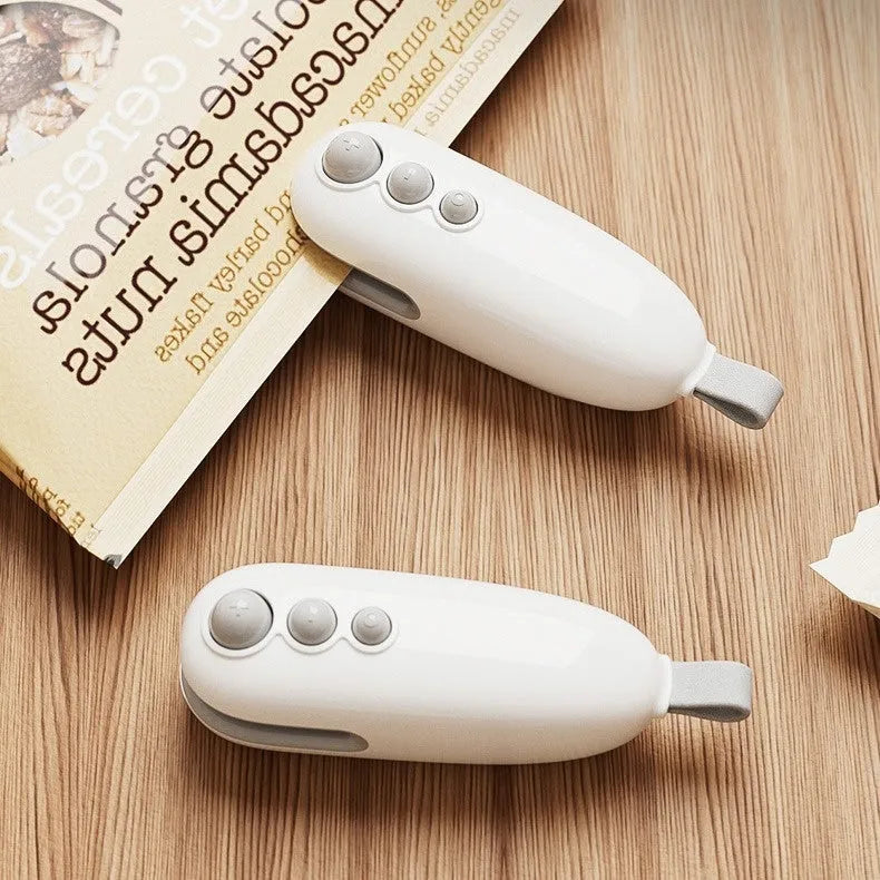 Household mini sealing machine in ivory white with automatic electric thermal capper on surface