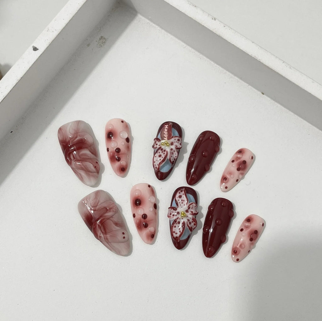 Hand-painted three-dimensional carved almond colour wear nails showing rose pattern in medium length