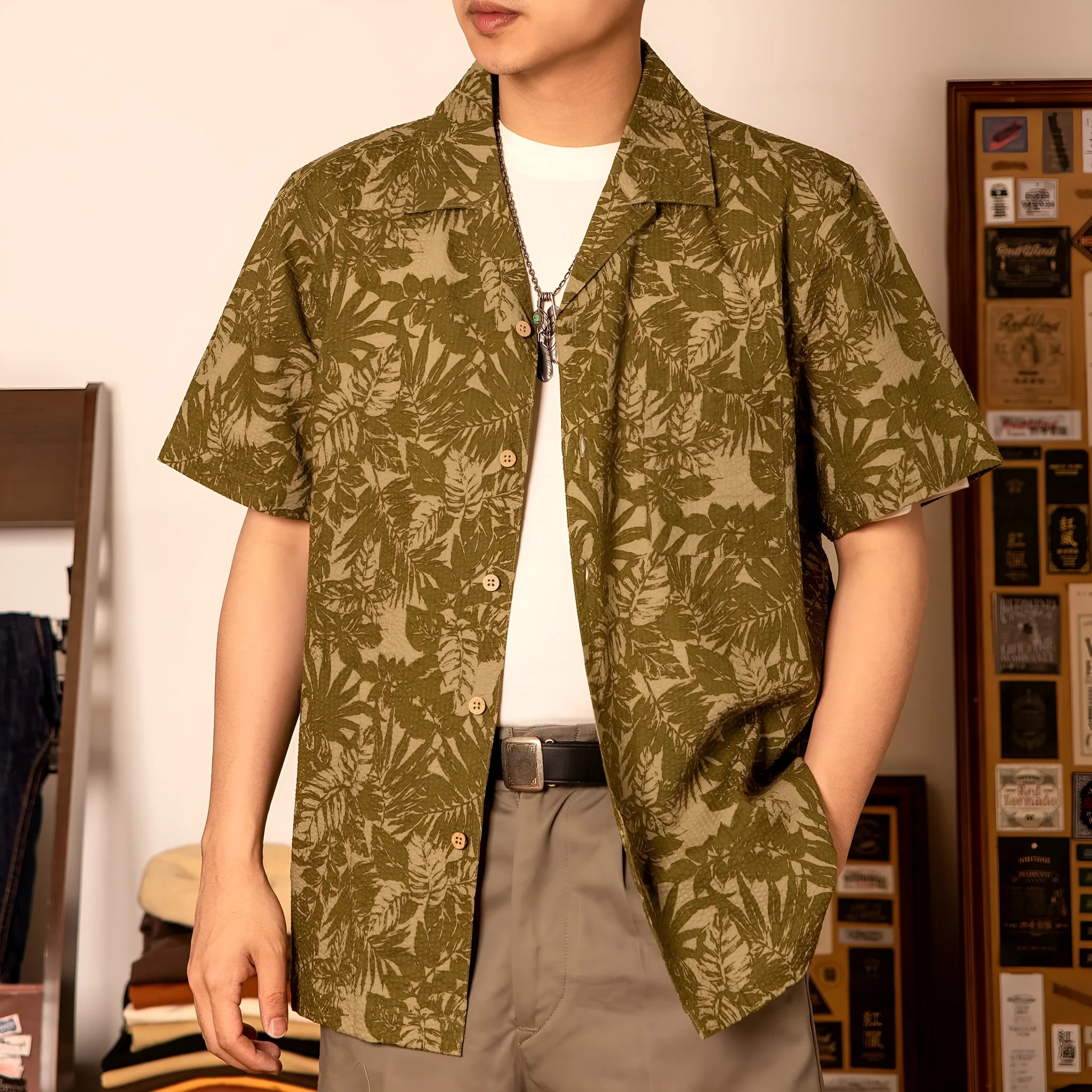 Man wearing a vintage floral print seersucker shirt with a Cuban collar in a green colour, showing loose fit.