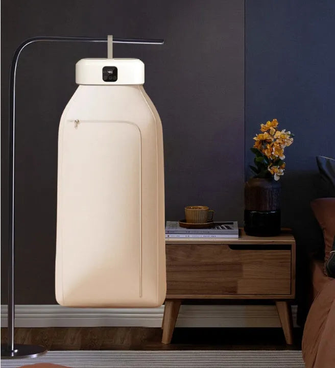 White cylindrical foldable laundry drier with remote control on flat surface