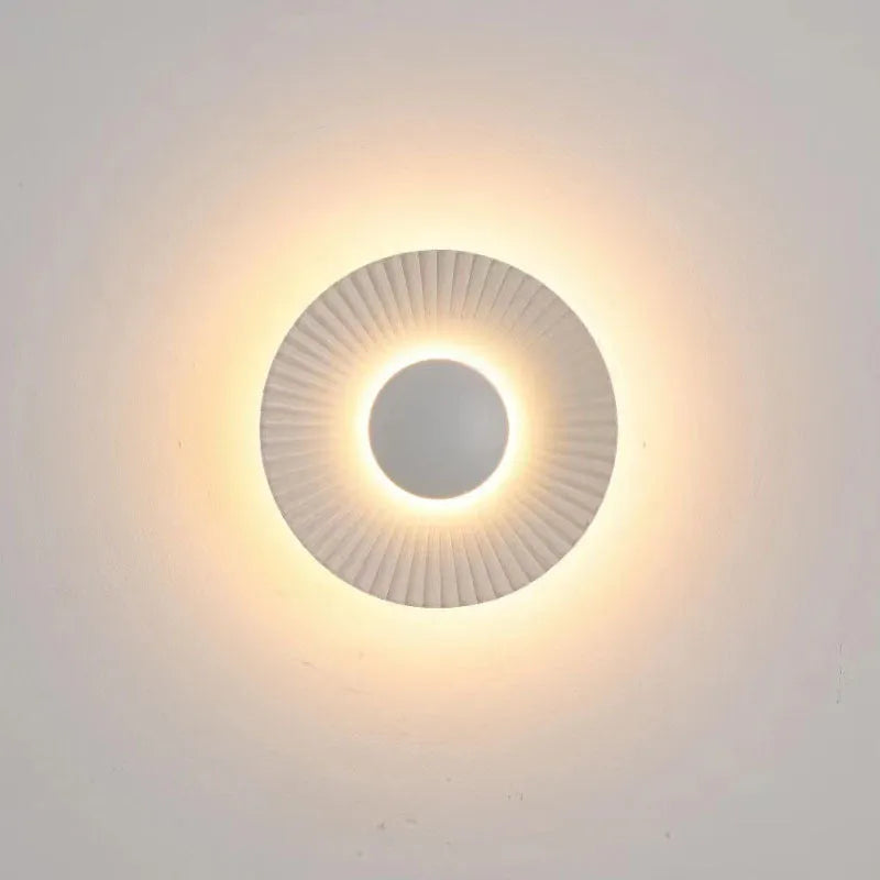 Round aluminium wall lamp mounted on a wall, showing a white and gold two-tone finish.