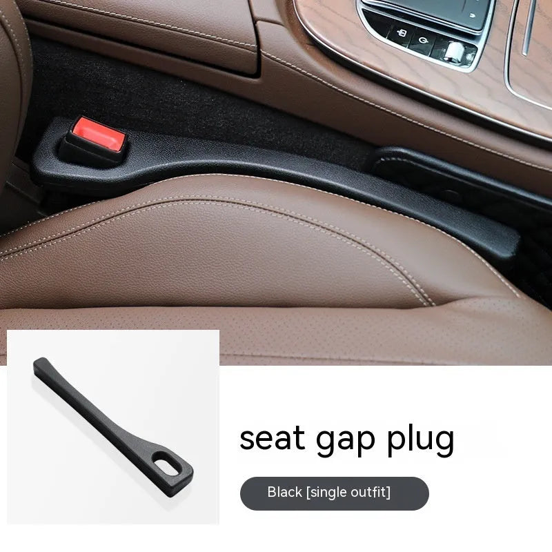 A flexible polyurethane car seat gap filler strip in black, placed between a car seat and centre console.