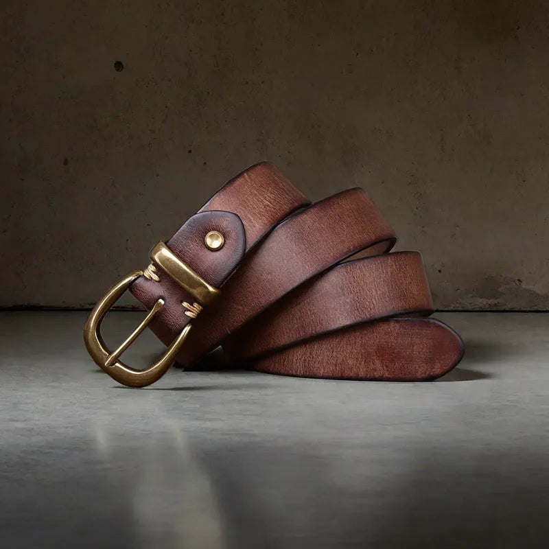 Men's brown casual leather belt with copper pin buckle on a jeans background.