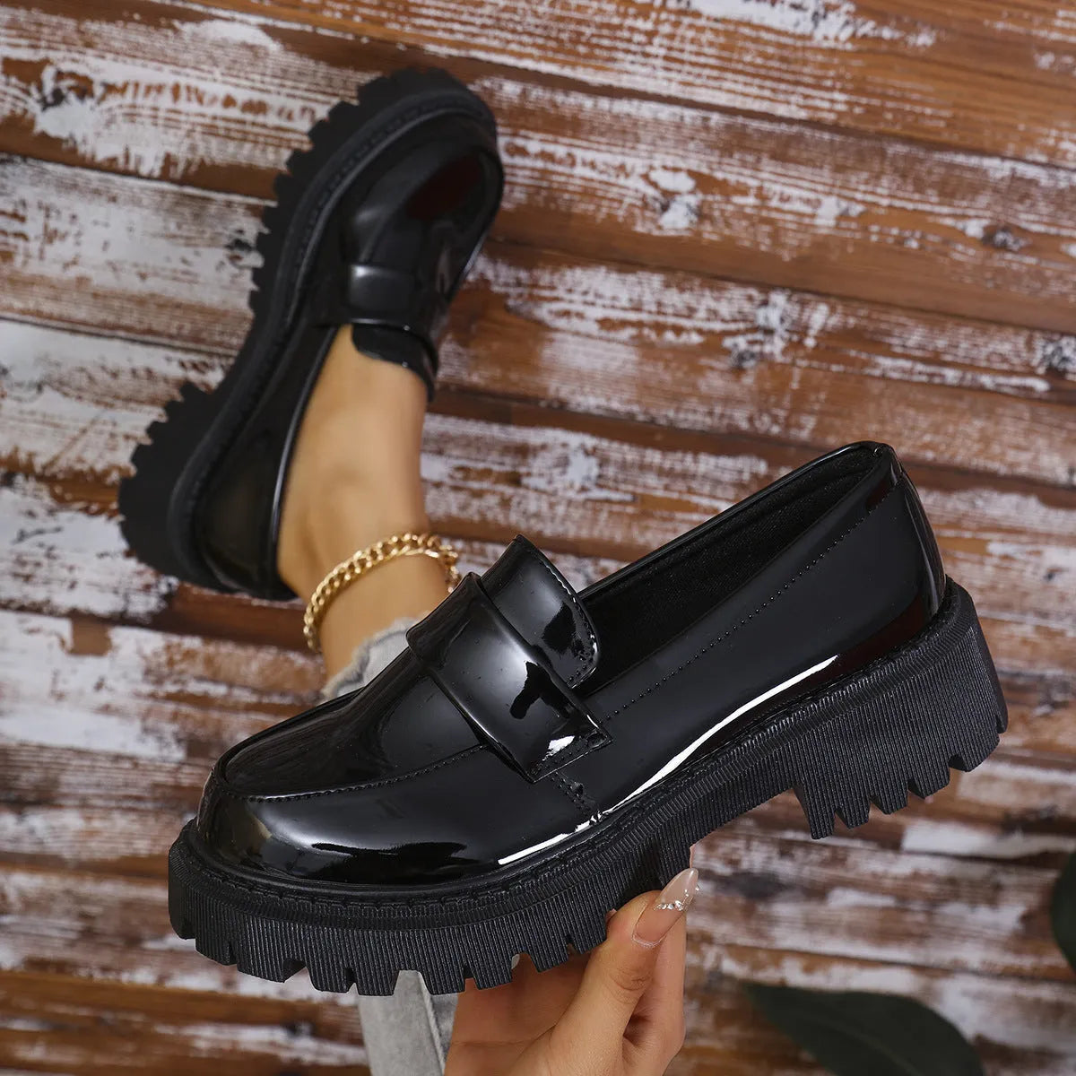 Women's black slip-on loafers with a chunky block heel and platform sole, shown from the side.