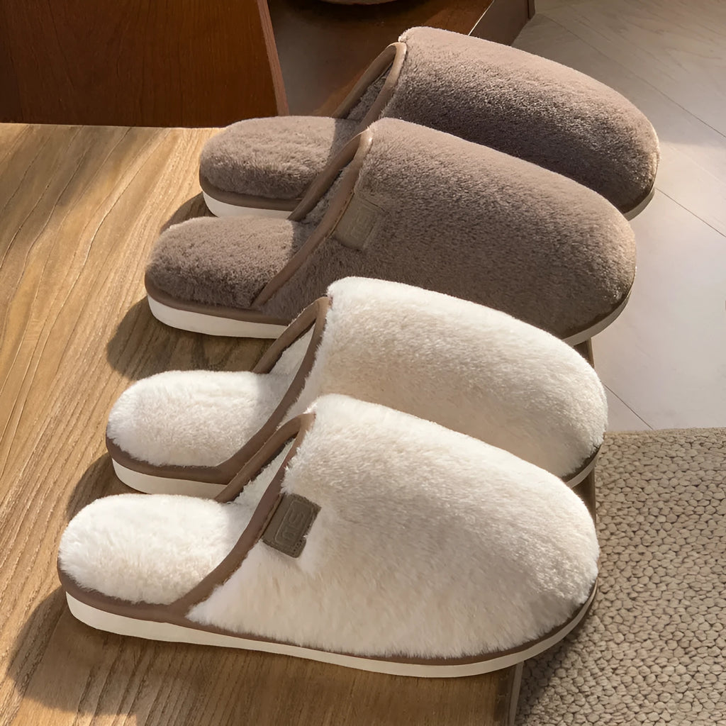 A pair of solid colour plush winter slippers with a non-slip PVC sole and car stitching detail.