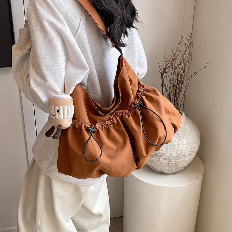 Soft green pleated foldable crossbody bag showing split pocket and internal mobile phone compartment
