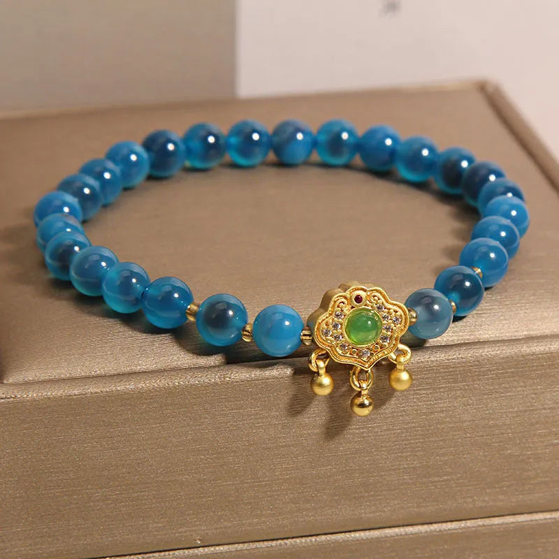 Blue sugar heart agate safety lock pendant on a crystal women's bracelet with rhinestone details.