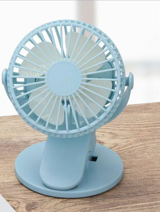 White USB clip fan with plastic blades mounted on desk edge showing piano button switch