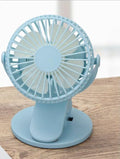 White USB clip fan with plastic blades mounted on desk edge showing piano button switch