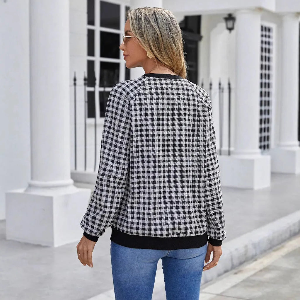 Black plaid and stripe pattern pullover sweater with long sleeves on mannequin
