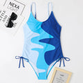 Women's sleeveless one-piece swimsuit in a striped print, showing backless design and available in multiple colours.