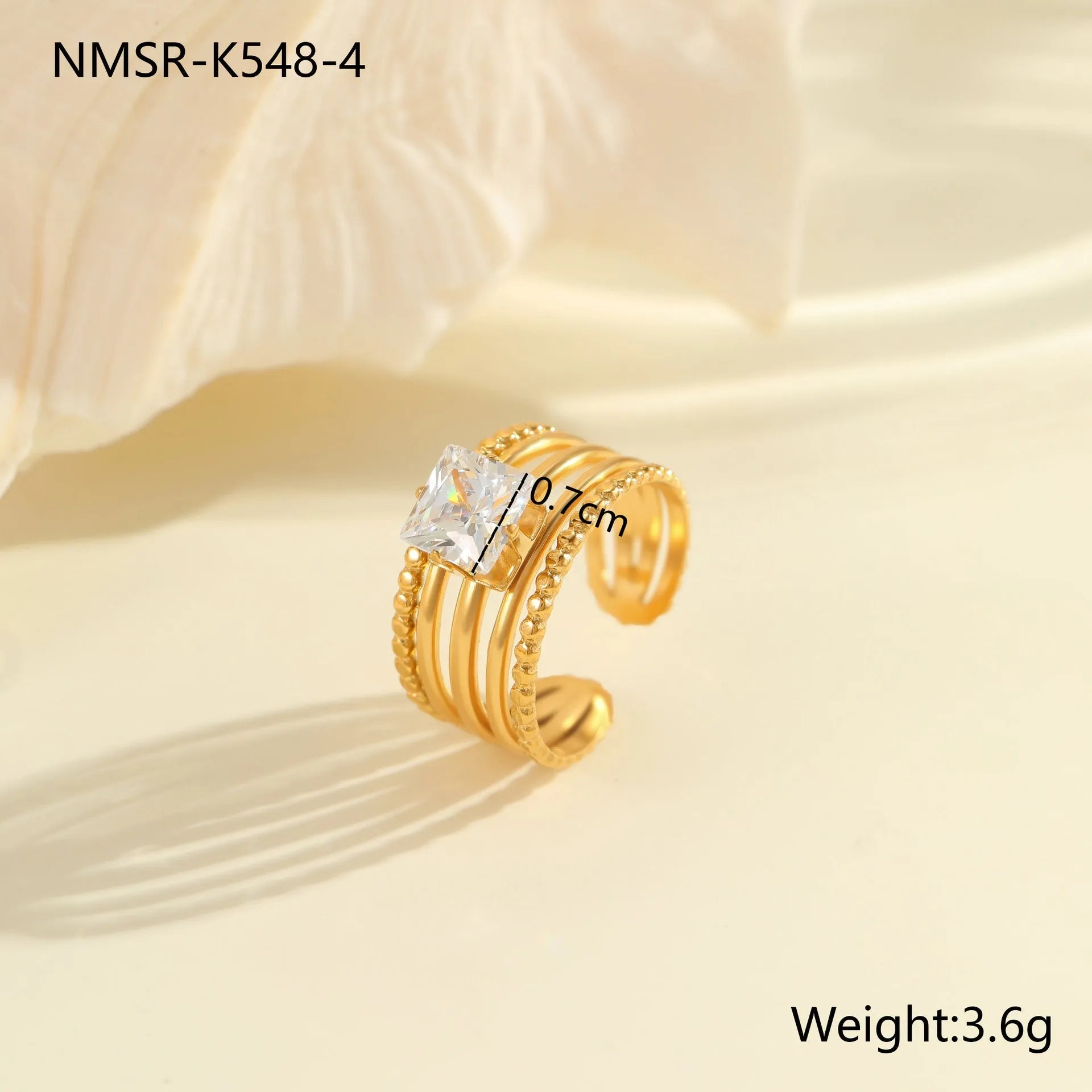 Gold inlaid zircon geometric heart and drop shape stainless steel ring on white background.
