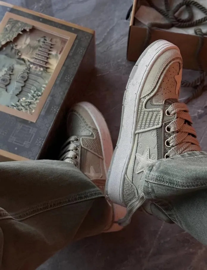 Green low-top casual trainers with star pattern stitching and a white rubber sole.