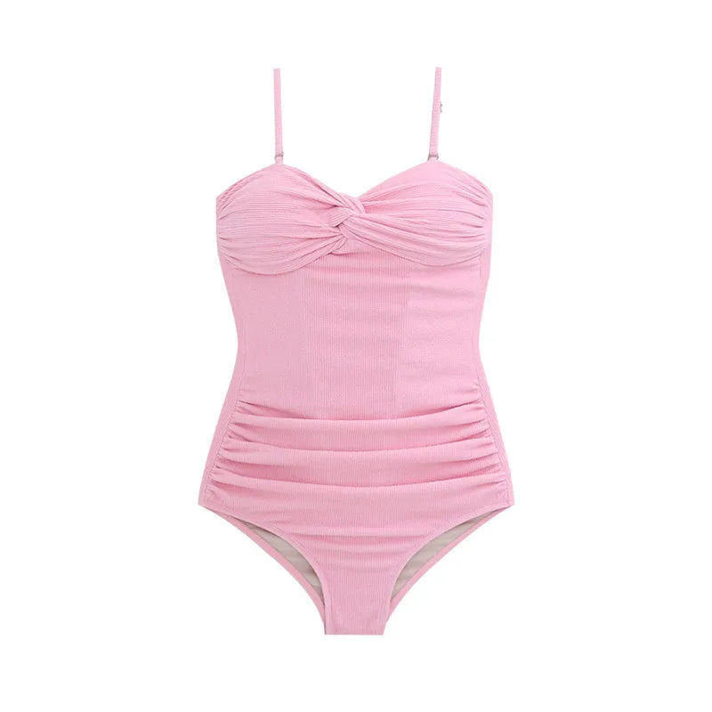 Women's black strapped jumpsuit one-piece swimsuit on a mannequin, side view.