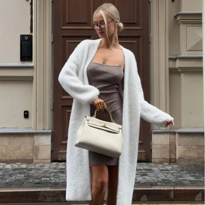 White long knitted cardigan jacket with regular sleeves on a hanger.