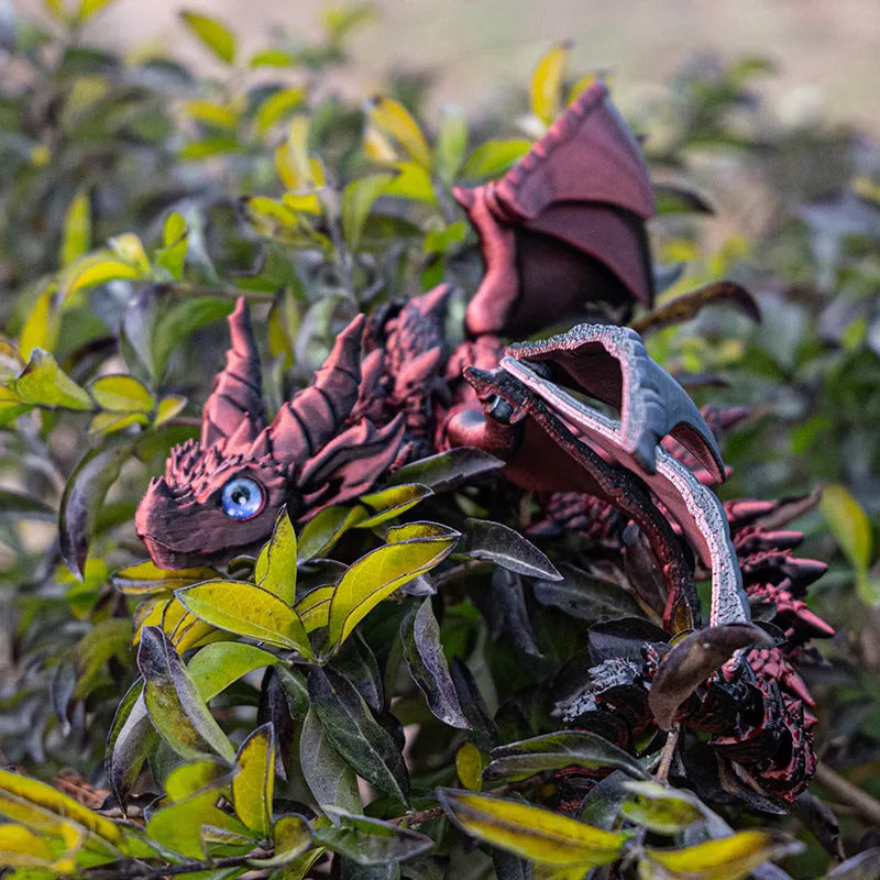 Red and gold 3D printed dragon wings toy decoration on a white background.