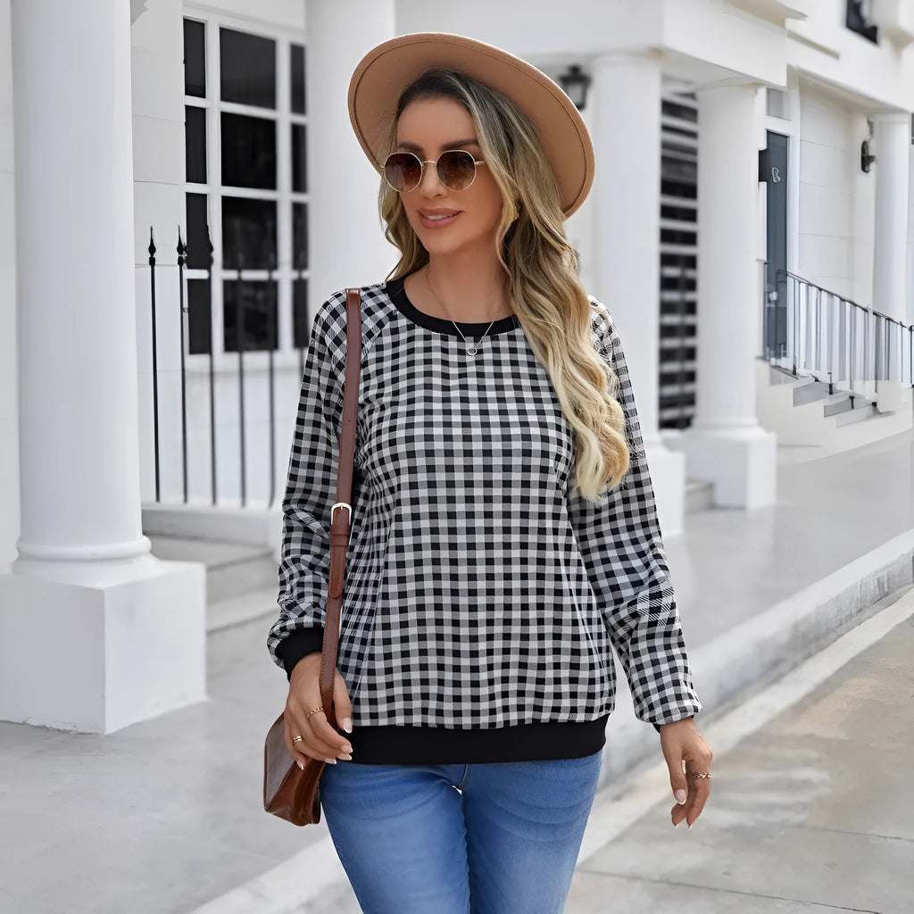 Black plaid and stripe pattern pullover sweater with long sleeves on mannequin
