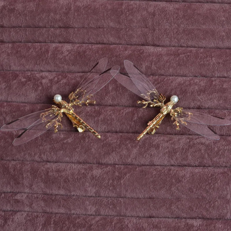 Golden alloy dragonfly-shaped side clip headdress for women on a white background.
