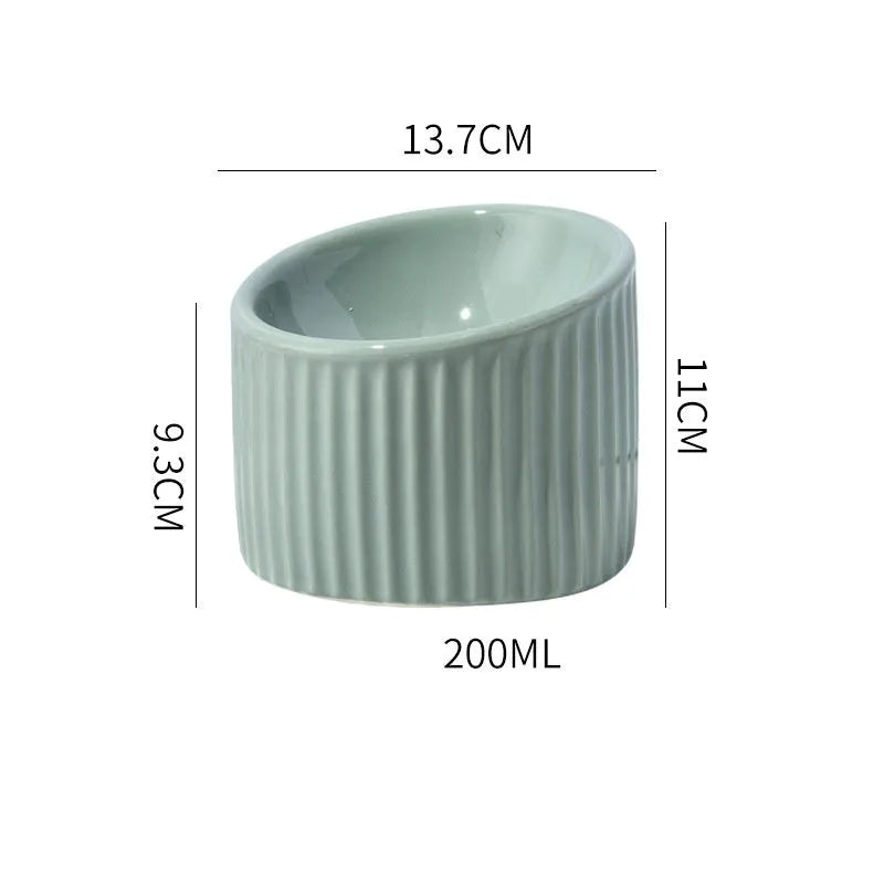 A dark green round ceramic cat bowl elevated on a base, shown at an angle.