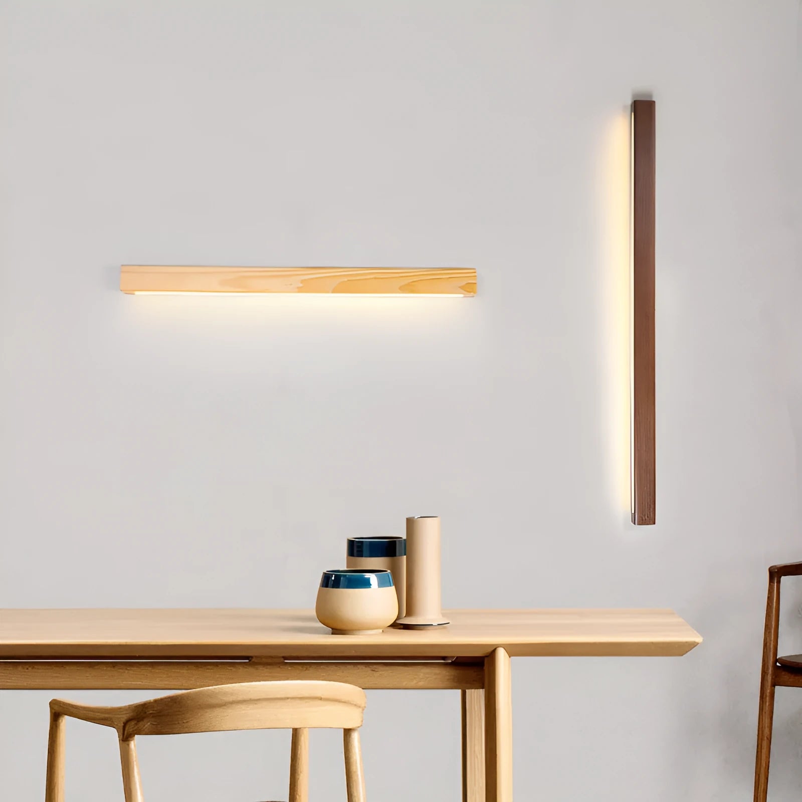 Walnut colour minimalist wooden and acrylic strip wall lamp in three length options on a white wall.