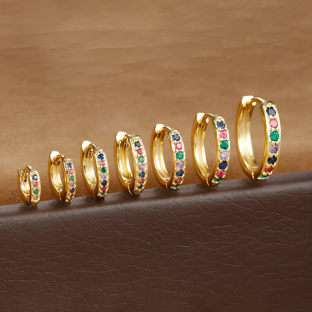 Circle zircon perforated stud earrings in gold, rose gold, and silver colour on a white background.