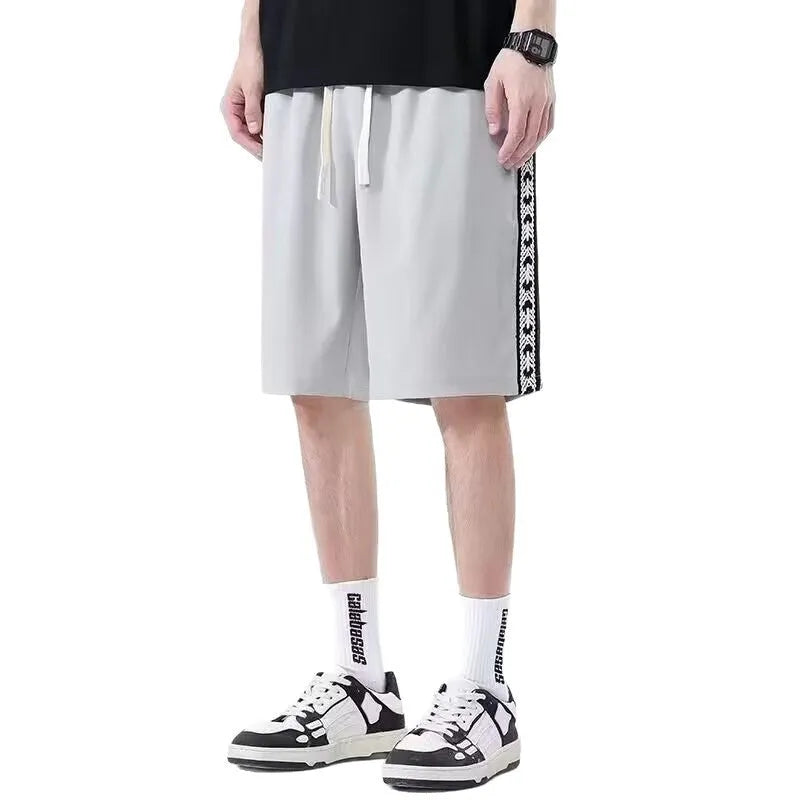 Men's black loose-fit micro-elastic track pants shown in a casual standing pose.