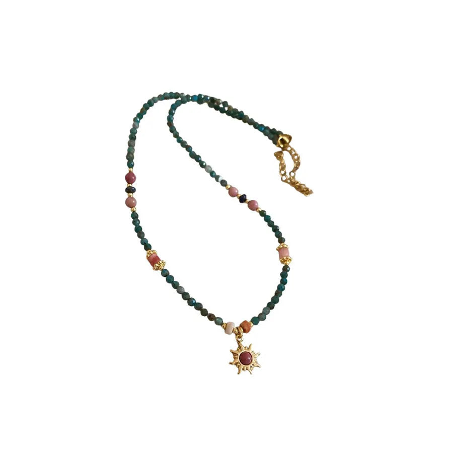 Sun necklace with a stone geometric pendant and freshwater pearls on a clavicle chain.